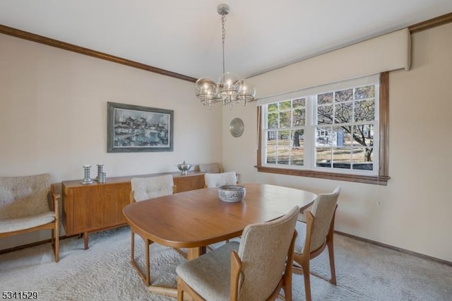 dining area with light carpet, baseboards, an inviting chandelier, and crown molding