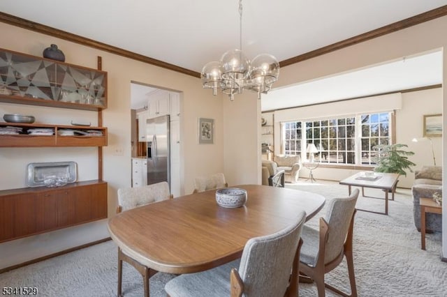 dining area featuring carpet floors, ornamental molding, and a notable chandelier