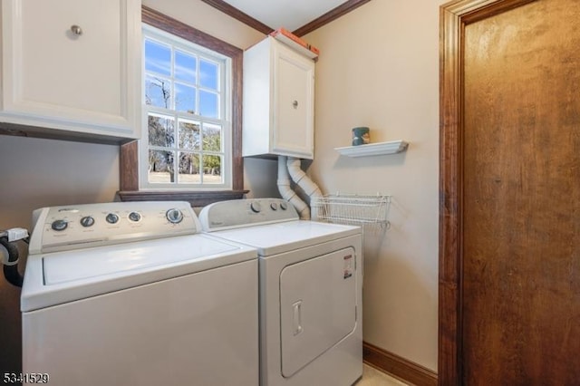 laundry area featuring washer and dryer, cabinet space, crown molding, and baseboards