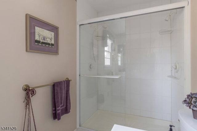 bathroom with a shower stall and toilet