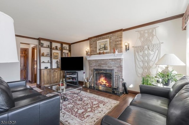 living area featuring baseboards, a fireplace, ornamental molding, and wood finished floors