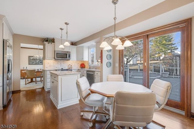 dining space featuring dark wood-type flooring and baseboards