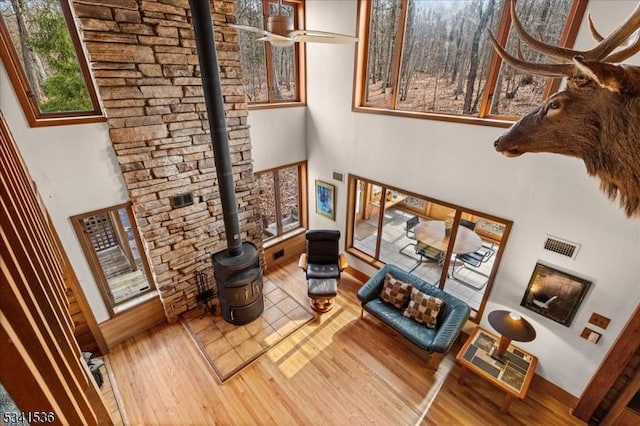 living room featuring visible vents, a towering ceiling, and wood finished floors