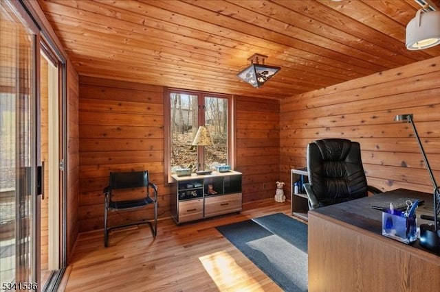 office space with light wood-type flooring, wooden ceiling, and wood walls