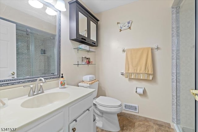 bathroom featuring toilet, vanity, visible vents, baseboards, and an enclosed shower