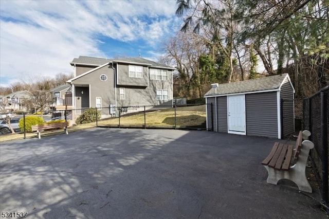 exterior space with an outbuilding, fence, and a storage unit