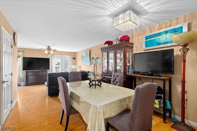 dining room featuring ceiling fan, light wood-style flooring, and baseboards