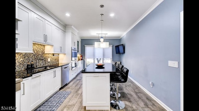 kitchen with tasteful backsplash, appliances with stainless steel finishes, light wood-style floors, ornamental molding, and white cabinetry