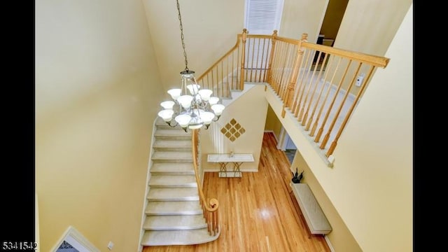 stairs with a towering ceiling and wood finished floors