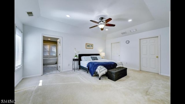 carpeted bedroom with ensuite bathroom, recessed lighting, visible vents, baseboards, and a raised ceiling