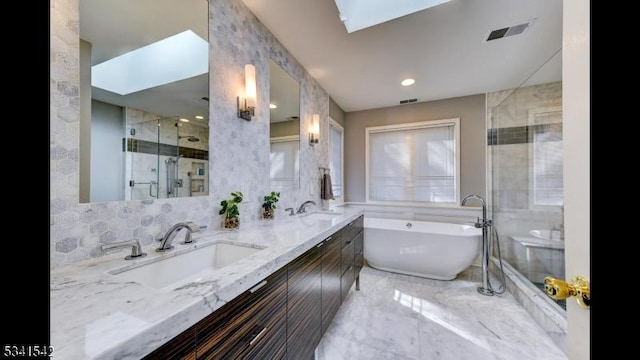 bathroom with a skylight, visible vents, and a sink