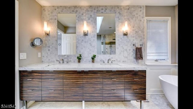 bathroom featuring double vanity, a freestanding bath, an enclosed shower, and a sink