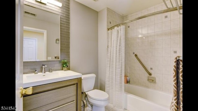 bathroom featuring toilet, vanity, visible vents, decorative backsplash, and shower / tub combo with curtain