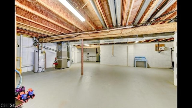 unfinished below grade area featuring heating unit and gas water heater