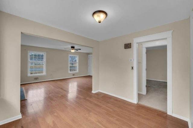 empty room with ceiling fan, baseboards, and light wood-style floors