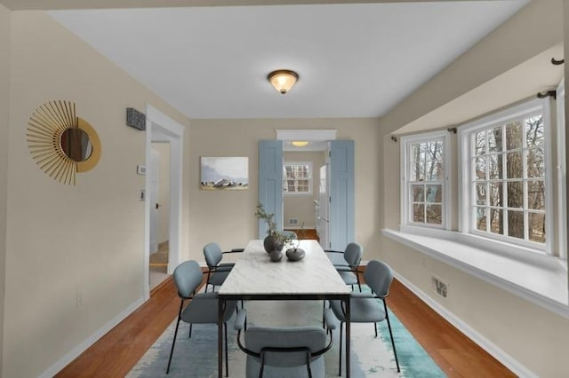 dining area with baseboards and wood finished floors