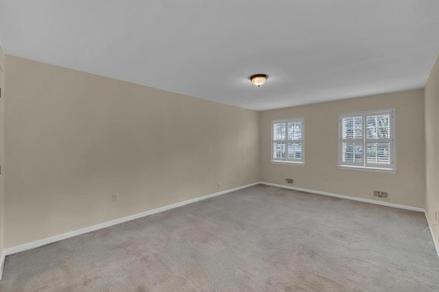 empty room featuring carpet flooring and baseboards