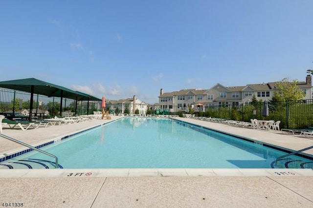 pool with a residential view, fence, and a patio area