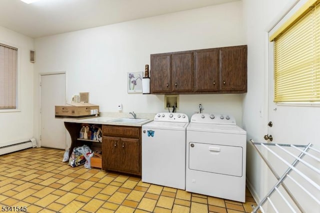 laundry room featuring cabinet space, a baseboard heating unit, washer and clothes dryer, and a sink