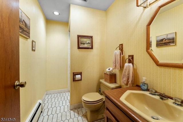 bathroom with toilet, a baseboard heating unit, vanity, tile patterned floors, and wallpapered walls