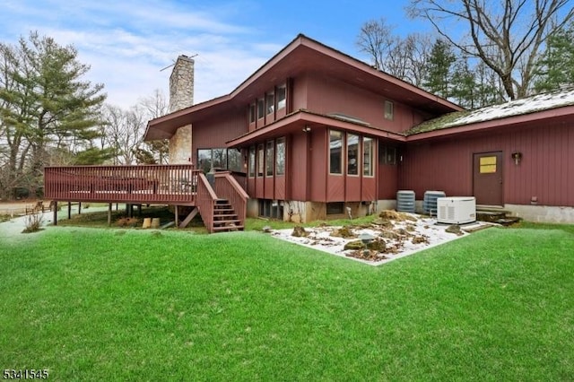 rear view of house with a lawn, a chimney, and a wooden deck