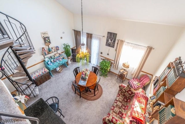 living room with carpet floors, stairway, high vaulted ceiling, and a healthy amount of sunlight