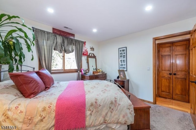 carpeted bedroom featuring recessed lighting, visible vents, and baseboards