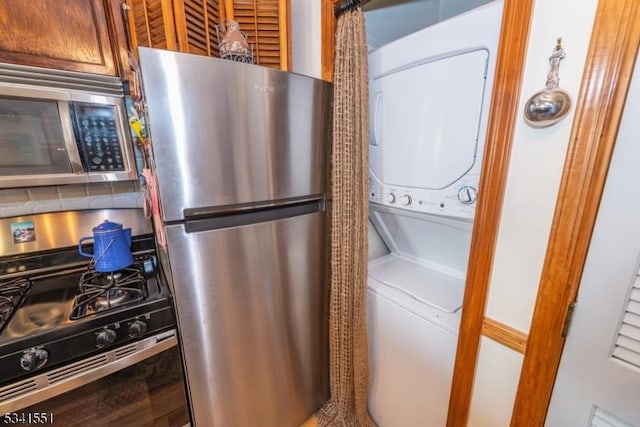 clothes washing area featuring laundry area and stacked washer / drying machine