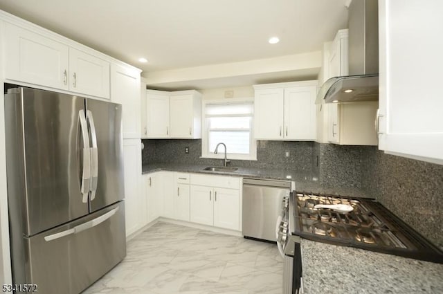 kitchen featuring wall chimney exhaust hood, marble finish floor, stainless steel appliances, white cabinetry, and a sink