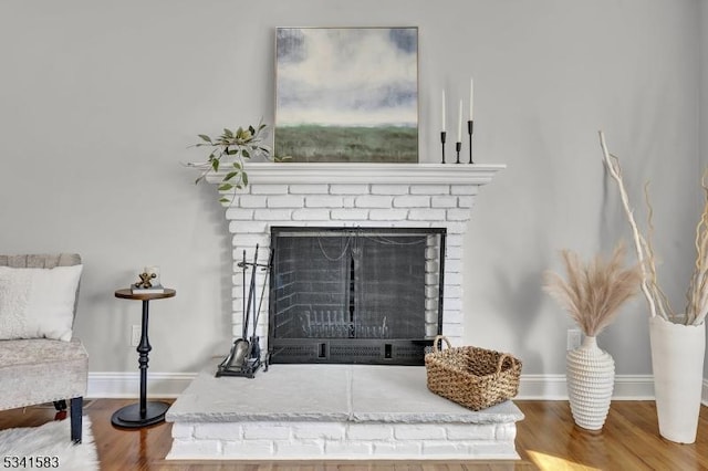 room details with a fireplace, wood finished floors, and baseboards