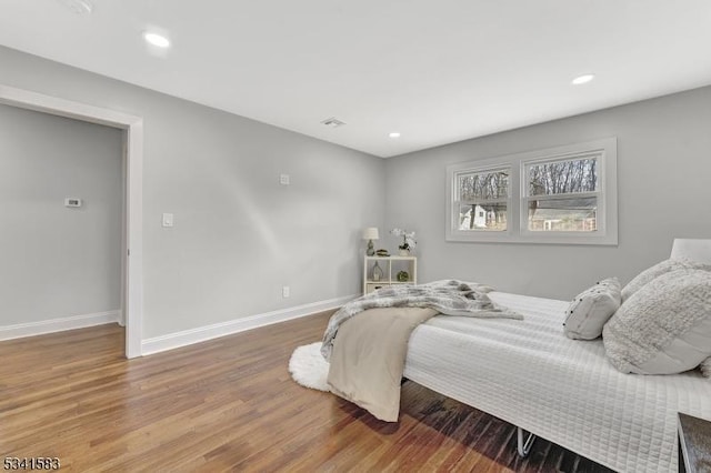 bedroom featuring visible vents, baseboards, wood finished floors, and recessed lighting