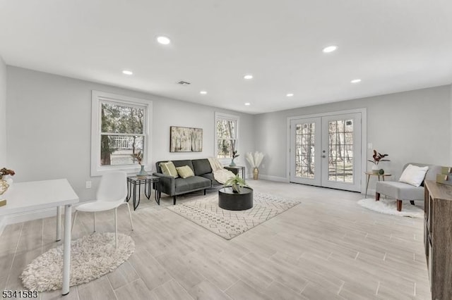 living room featuring recessed lighting, visible vents, baseboards, french doors, and light wood finished floors