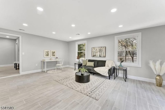 living area featuring light wood finished floors, visible vents, baseboards, and recessed lighting