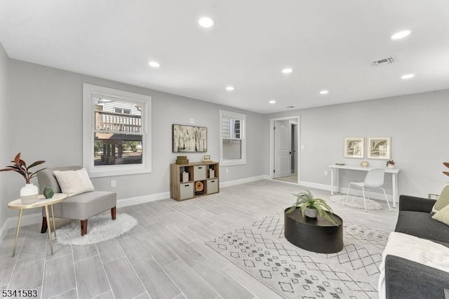 living room with light wood-type flooring, recessed lighting, visible vents, and baseboards