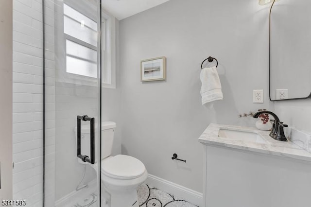 bathroom featuring a shower stall, baseboards, vanity, and toilet