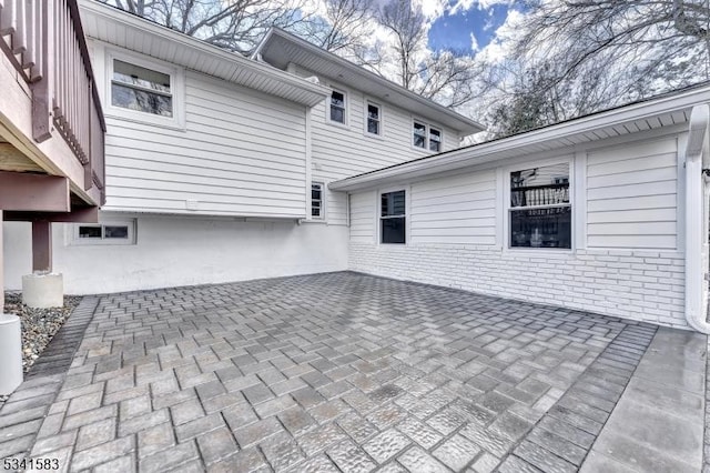 view of home's exterior featuring brick siding and a patio