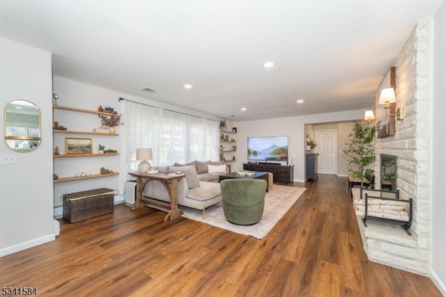 living room with a fireplace, recessed lighting, visible vents, wood finished floors, and baseboards