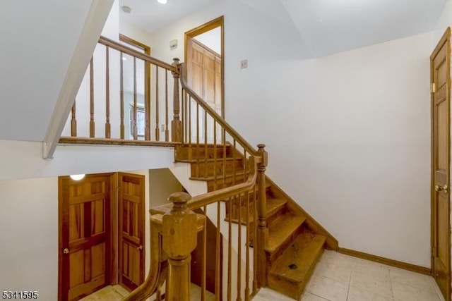 stairs featuring tile patterned floors and baseboards