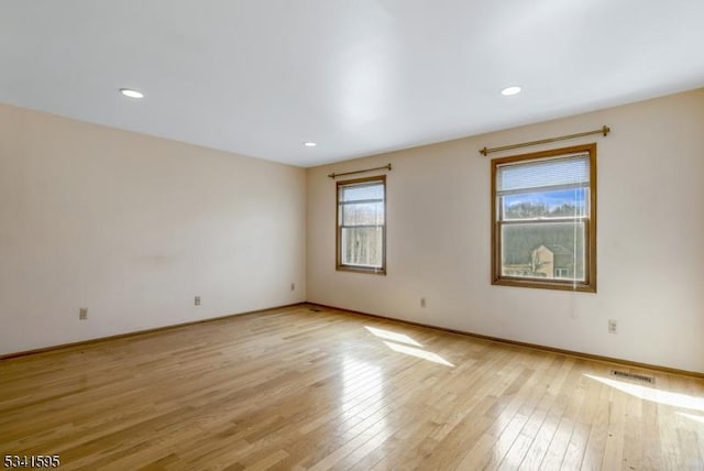 unfurnished room featuring visible vents, recessed lighting, baseboards, and light wood-style floors