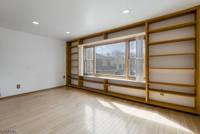 empty room with recessed lighting, baseboards, and wood finished floors