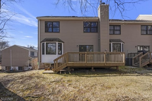 rear view of property with a wooden deck and a chimney