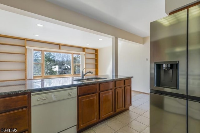 kitchen with dark stone counters, open shelves, stainless steel fridge with ice dispenser, a sink, and dishwasher