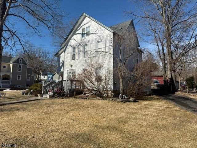 view of side of home with a yard