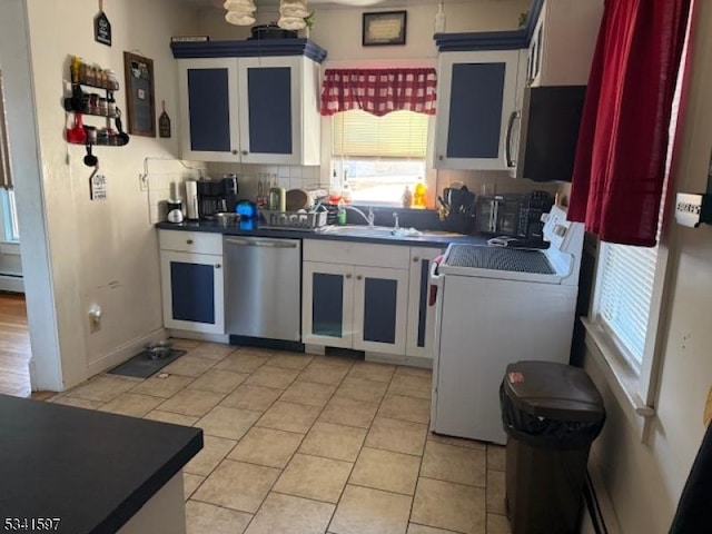 kitchen with appliances with stainless steel finishes, dark countertops, and a sink