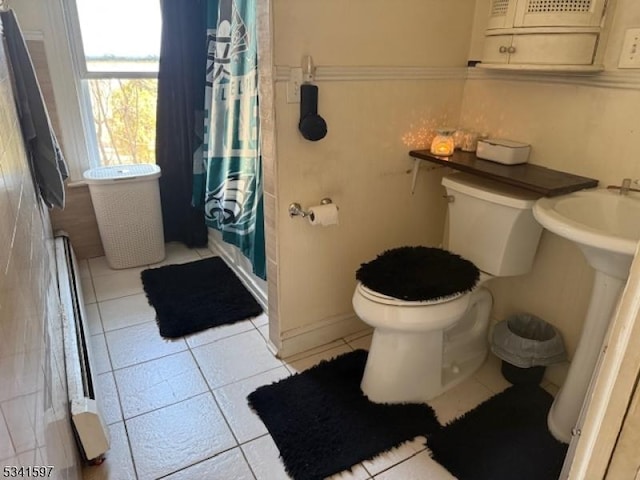 full bathroom with a shower with curtain, toilet, and tile patterned floors