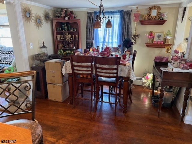 dining space with a baseboard radiator, ornamental molding, and wood finished floors