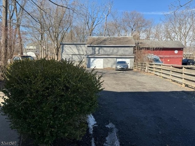 view of side of home with fence and driveway