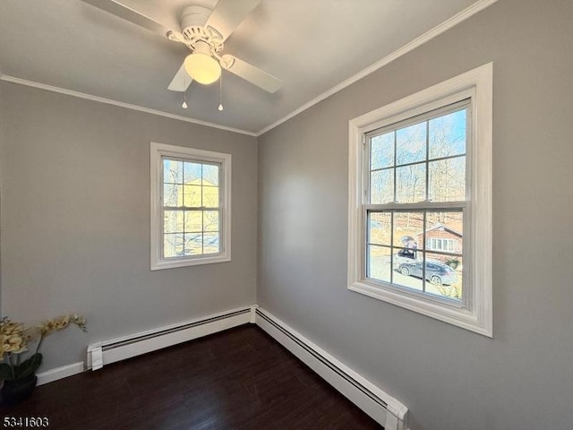 unfurnished room featuring a baseboard heating unit, dark wood-type flooring, and crown molding