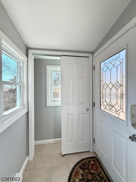 entrance foyer featuring light tile patterned floors and baseboards