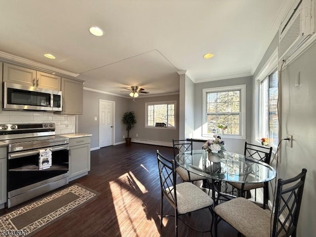 kitchen with crown molding, gray cabinets, light countertops, decorative backsplash, and appliances with stainless steel finishes